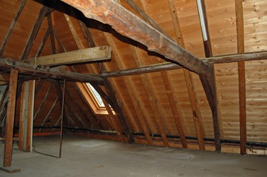 <p>Overzicht van het achterste deel van de kapconstructie. De reparaties uit 2001 zijn goed te herkennen aan de lichtere houtsoort. De hijsbalk aan de achterzijde is waarschijnlijk in 1920 aangebracht ten behoeve van het garagebedrijf. </p>
